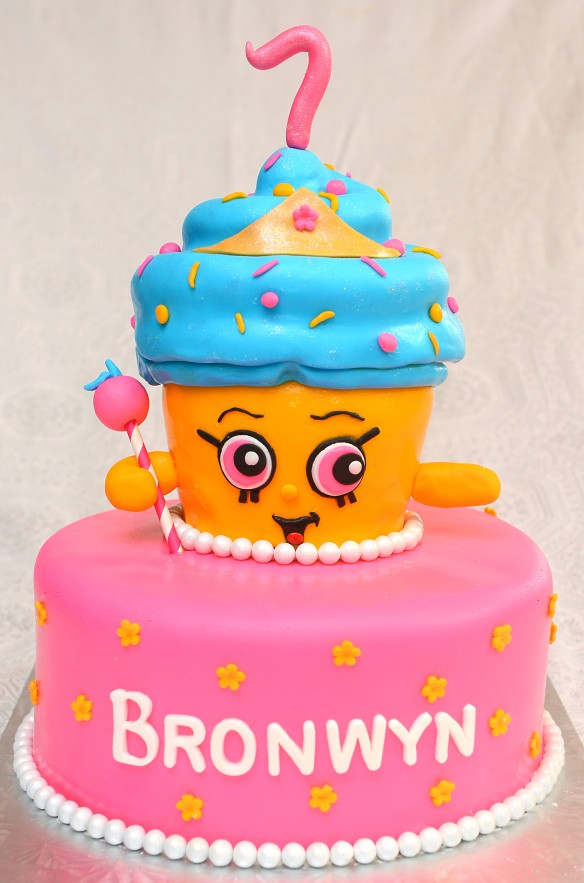 Gâteau 10 pouces rond  et gâteau en forme de cupcake à la fraise avec glaçage meringue suisse à la vanille. Recouvert de fondant  et décoré pour représenter le shopkin ''Cupcake Queen''.